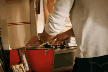 a man is playing a record in a red case with a picture of a family on it