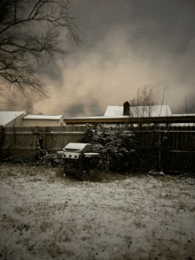 a snowy backyard with a bbq in the foreground