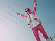 a woman in a pink and white costume is flying through the air