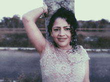 a woman with curly hair wearing a white lace top