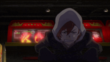 a man in a hooded sweatshirt stands in front of a red machine that says king