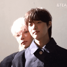 a couple of young men standing next to each other with the word tea in the corner