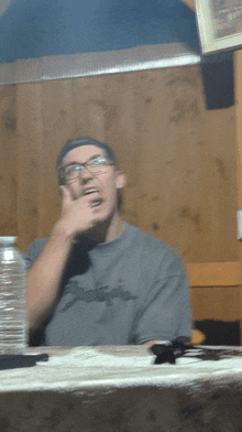 a man sitting at a table with a bottle of water