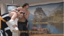 two men wrestling in front of a painting that says i 'm gonna drown you !