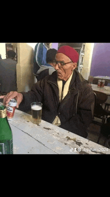 a man is sitting at a table with a can of marlboro beer