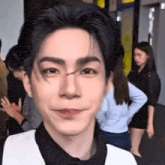 a close up of a person 's face with a woman in the background .