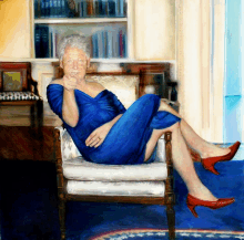 a woman in a blue dress is sitting in a chair with her legs crossed