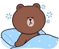 a brown bear is laying on a bed with a blue comforter