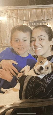 a woman is holding a puppy next to a boy in front of a sign that says " calories "