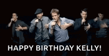 a group of men are singing into microphones on a stage and they are dancing .