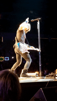 a man is singing into a microphone while playing a guitar