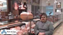 a man in a chef 's hat sits in front of a display case with a sign that says radio del capo