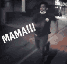 a man wearing a mask is walking down a street with the word mama written on the ground