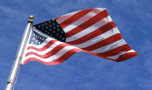 a large american flag is flying in the wind