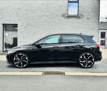 a black car is parked in front of a building