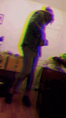 a blurry picture of a person standing in a room with a purple and yellow background .