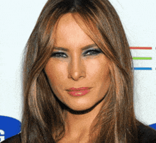 a woman with long brown hair and blue eyeshadow