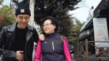 a man and a woman are walking down a sidewalk in front of a sign that says ' dream '