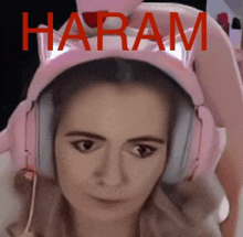 a woman wearing pink headphones and a cat ear headband with the word haram written in red