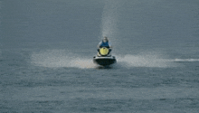 a man is riding a jet ski through the ocean .