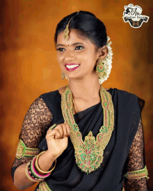 a woman wearing a black saree and gold jewelry with a fashion design logo