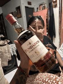 a woman holds a bottle of fundador super special rum