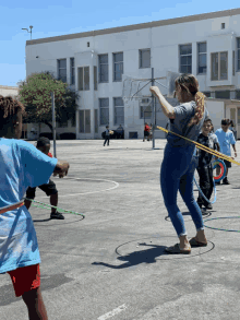 a group of children playing with hula hoops in a parking lot