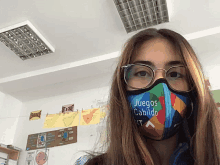 a girl wearing glasses and a face mask that says juegos cabildo