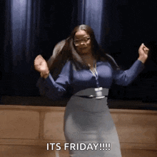 a woman is dancing on a stage and saying `` it 's friday !!! '' .