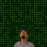 a man stands in front of a green background with the number 11