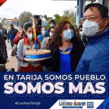 a group of people wearing face masks and holding a cake with the words en tarija somos pueblo somos mas