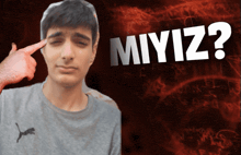 a man is pointing at his eye in front of a sign that says miyiz