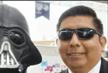 a man wearing sunglasses and a darth vader mask