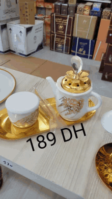 a table with a teapot and a cup on it and 189 dh written on the table