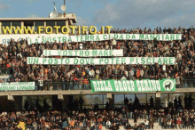 a large crowd of people watching a soccer game with a banner that says ricca group serino