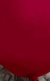 a close up of a clown with a red balloon in his hat