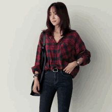 a woman wearing a red plaid shirt and jeans