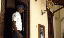 a security guard stands in front of a building with a sign on the wall that says ' uni ' on it