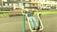 a man is doing exercises in a park in front of a building that says ' a ' on the front