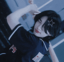 a girl with a star in her hair is wearing a blue shirt with the letter n on the front