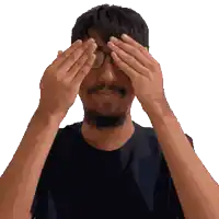 a man covering his eyes with his hands and wearing glasses