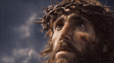a man with a crown of thorns on his head looks up