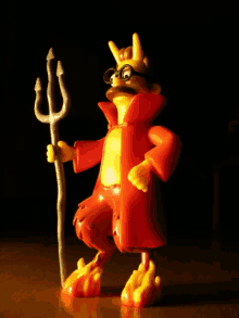 a toy devil with glasses and a trident