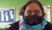 a woman wearing a black face mask and a scarf