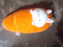 a stuffed carrot with a white rabbit on top