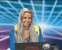 a woman sitting in front of a laptop with a sticker that says zappakal