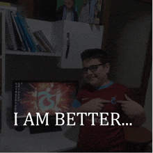 a boy wearing a shirt that says " i am better " points to his chest