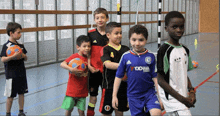 a boy wearing a blue yokohama jersey stands in a line with other kids