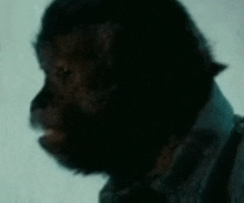 a close up of a man 's face in a dark room with a blurred background .