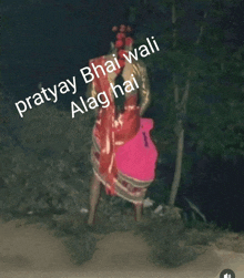 a woman in a red dress is standing in the dark with the words prathay bhai wali along the bottom of the image